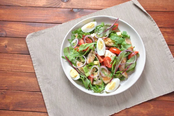 Avokado ve kiraz domates, roka ve pancar tavuk salatası bırakır. Ahşap arka plan üzerinde tavuk ve sebze ile sağlıklı öğle yemeği kase. Sağlıklı gıda kavramı