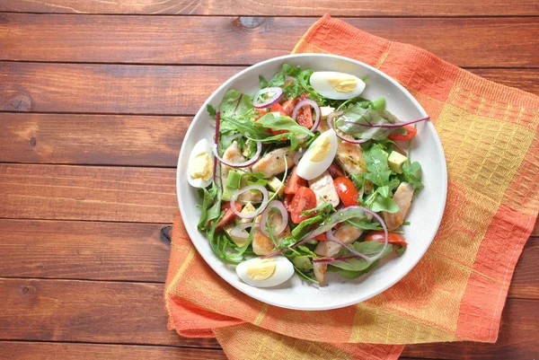 Avokado ve kiraz domates, roka ve pancar tavuk salatası bırakır. Ahşap arka plan üzerinde tavuk ve sebze ile sağlıklı öğle yemeği kase. Sağlıklı gıda kavramı