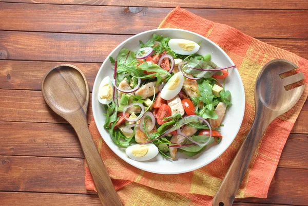 Avokado ve kiraz domates, roka ve pancar tavuk salatası bırakır. Ahşap arka plan üzerinde tavuk ve sebze ile sağlıklı öğle yemeği kase. Sağlıklı gıda kavramı