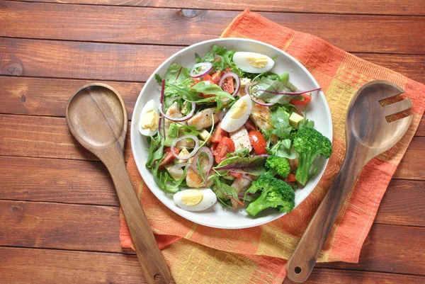 Avokado ve kiraz domates, roka ve pancar tavuk salatası bırakır. Ahşap arka plan üzerinde tavuk ve sebze ile sağlıklı öğle yemeği kase. Sağlıklı gıda kavramı