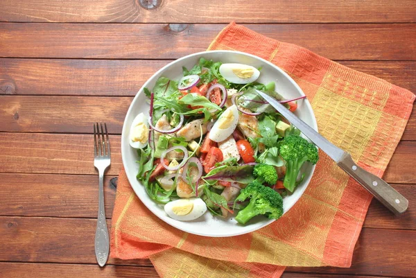 Avokado ve kiraz domates, roka ve pancar tavuk salatası bırakır. Ahşap arka plan üzerinde tavuk ve sebze ile sağlıklı öğle yemeği kase. Sağlıklı gıda kavramı