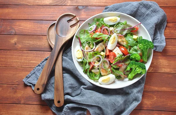 Avokado ve kiraz domates, roka ve pancar tavuk salatası bırakır. Ahşap arka plan üzerinde tavuk ve sebze ile sağlıklı öğle yemeği kase. Sağlıklı gıda kavramı