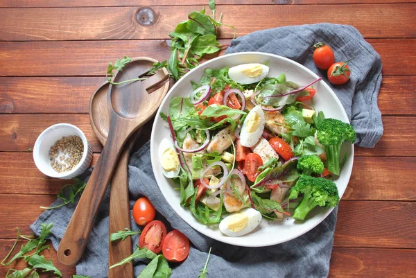 Avokado ve kiraz domates, roka ve pancar tavuk salatası bırakır. Ahşap arka plan üzerinde tavuk ve sebze ile sağlıklı öğle yemeği kase. Sağlıklı gıda kavramı