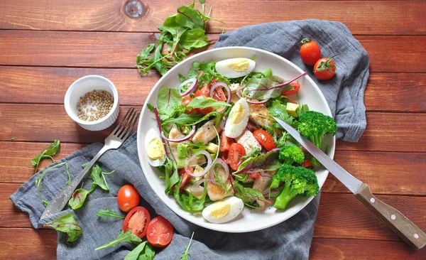 Avokado ve kiraz domates, roka ve pancar tavuk salatası bırakır. Ahşap arka plan üzerinde tavuk ve sebze ile sağlıklı öğle yemeği kase. Sağlıklı gıda kavramı