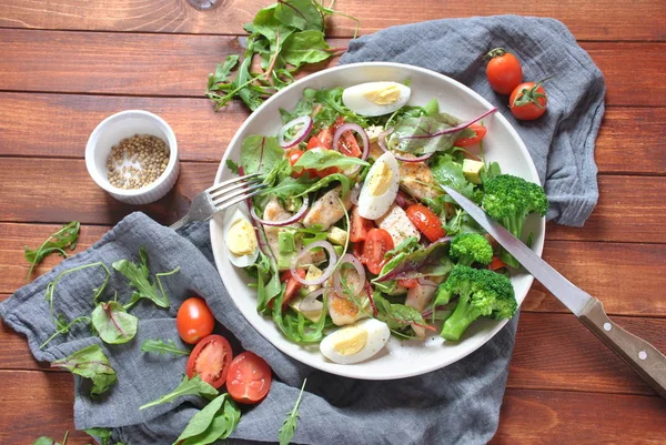 Avokado ve kiraz domates, roka ve pancar tavuk salatası bırakır. Ahşap arka plan üzerinde tavuk ve sebze ile sağlıklı öğle yemeği kase. Sağlıklı gıda kavramı