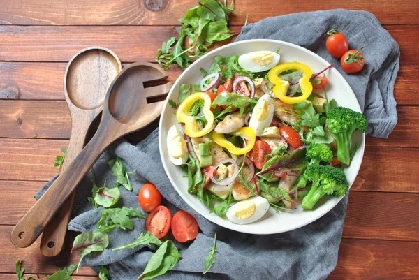 Avokado ve kiraz domates, roka ve pancar tavuk salatası bırakır. Ahşap arka plan üzerinde tavuk ve sebze ile sağlıklı öğle yemeği kase. Sağlıklı gıda kavramı