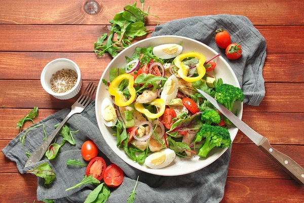 Avokado ve kiraz domates, roka ve pancar tavuk salatası bırakır. Ahşap arka plan üzerinde tavuk ve sebze ile sağlıklı öğle yemeği kase. Sağlıklı gıda kavramı