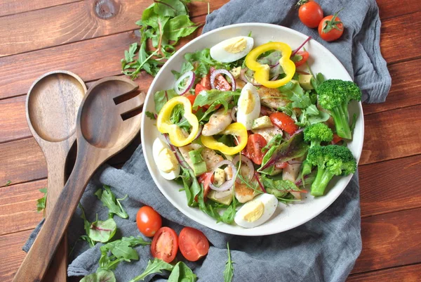 Avokado ve kiraz domates, roka ve pancar tavuk salatası bırakır. Ahşap arka plan üzerinde tavuk ve sebze ile sağlıklı öğle yemeği kase. Sağlıklı gıda kavramı