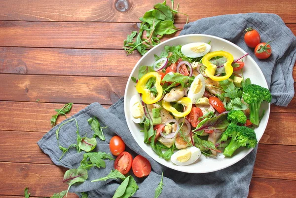 Avokado ve kiraz domates, roka ve pancar tavuk salatası bırakır. Ahşap arka plan üzerinde tavuk ve sebze ile sağlıklı öğle yemeği kase. Sağlıklı gıda kavramı