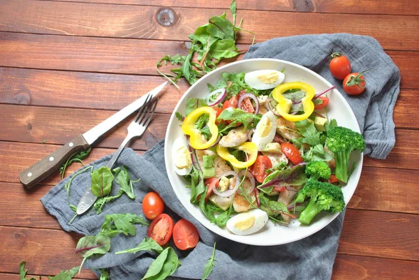 Avokado ve kiraz domates, roka ve pancar tavuk salatası bırakır. Ahşap arka plan üzerinde tavuk ve sebze ile sağlıklı öğle yemeği kase. Sağlıklı gıda kavramı