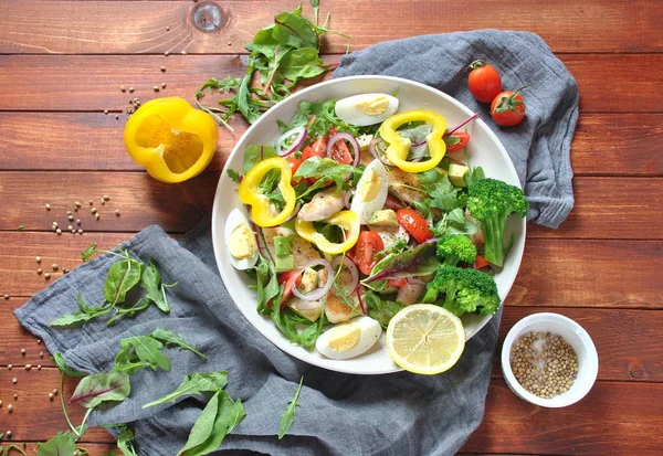 Avokado ve kiraz domates, roka ve pancar tavuk salatası bırakır. Ahşap arka plan üzerinde tavuk ve sebze ile sağlıklı öğle yemeği kase. Sağlıklı gıda kavramı