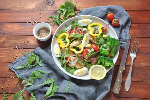 Avokado ve kiraz domates, roka ve pancar tavuk salatası bırakır. Ahşap arka plan üzerinde tavuk ve sebze ile sağlıklı öğle yemeği kase. Sağlıklı gıda kavramı