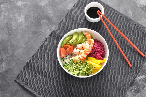 Taze deniz ürünleri yemek tarifi. Karides kase pirinç, kırmızı lahana, avokado, sarı tatlı biber ile poke. Gıda kavramı poke kase gri arka plan üzerinde 