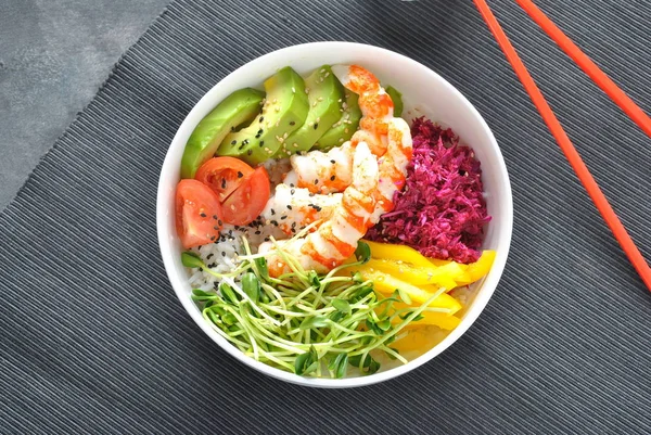 Taze deniz ürünleri yemek tarifi. Karides kase pirinç, kırmızı lahana, avokado, sarı tatlı biber ile poke. Gıda kavramı poke kase gri arka plan üzerinde 