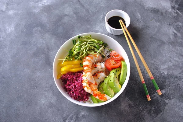 Taze deniz ürünleri yemek tarifi. Karides kase pirinç, kırmızı lahana, avokado, sarı tatlı biber ile poke. Gıda kavramı poke kase gri arka plan üzerinde 