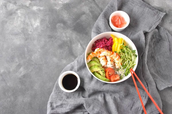 Taze deniz ürünleri yemek tarifi. Karides kase pirinç, kırmızı lahana, avokado, sarı tatlı biber ile poke. Gıda kavramı poke kase gri arka plan üzerinde 