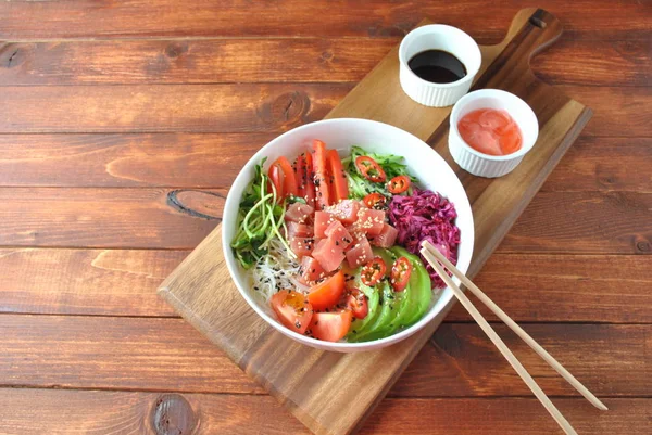 Organik gıda. Taze deniz ürünleri yemek tarifi. Ton balığı kase kristal erişte, taze kırmızı lahana, avokado, domates ile poke. Gıda kavramı poke kase ahşap arka plan üzerinde 