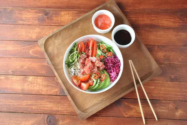 Organik gıda. Taze deniz ürünleri yemek tarifi. Ton balığı kase kristal erişte, taze kırmızı lahana, avokado, domates ile poke. Gıda kavramı poke kase ahşap arka plan üzerinde 