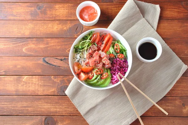 Organik gıda. Taze deniz ürünleri yemek tarifi. Ton balığı kase kristal erişte, taze kırmızı lahana, avokado, domates ile poke. Gıda kavramı poke kase ahşap arka plan üzerinde 