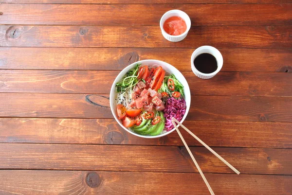 Organik gıda. Taze deniz ürünleri yemek tarifi. Ton balığı kase kristal erişte, taze kırmızı lahana, avokado, domates ile poke. Gıda kavramı poke kase ahşap arka plan üzerinde 