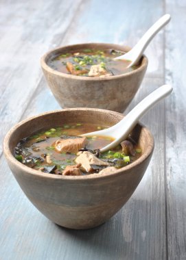 Japon miso çorbası ile taze orkinos, kurutulmuş yosun, tofu, shiitake mantar ahşap arka plan üzerinde ahşap bir kasede kurutulmuş