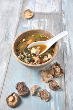 Japon miso çorbası ile taze orkinos, kurutulmuş yosun, tofu, shiitake mantar ahşap arka plan üzerinde ahşap bir kasede kurutulmuş