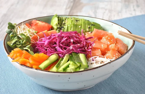 Fresh seafood recipe. Organic food. Fresh salmon poke bowl with crystal noodles, fresh red cabbage, avocado, cherry tomatoes. Food concept poke bowl
