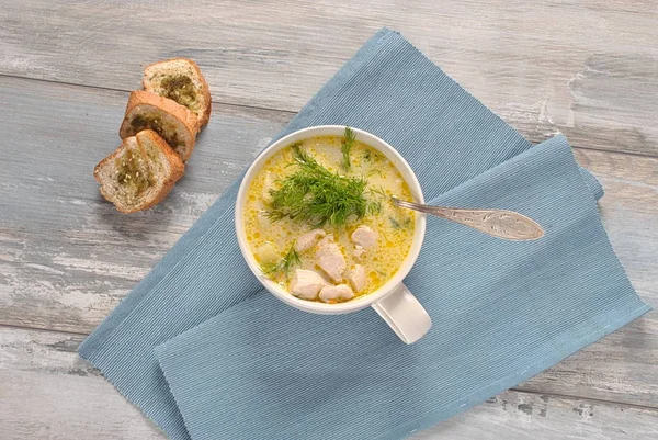 Chicken soup. Hot winter soup with chicken and potatoes. Chowder soup with chicken and potatoes. Fresh creamy soup with chicken and vegetables in white bowl on the wooden background. Healthy food