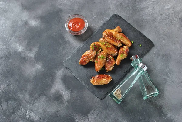 Izgara, Barbekü tavuk kanatları. Akşam yemeği ya da öğle yemeği için lezzetli yemekler. Kızarmış tavuk kanadı susam siyah arka plan ile. Fast food kavramı.
