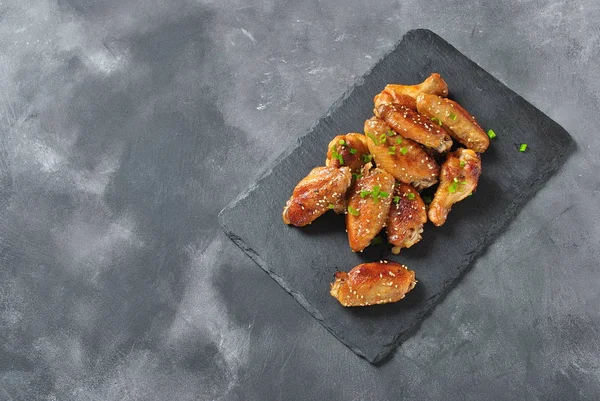 Izgara, Barbekü tavuk kanatları. Akşam yemeği ya da öğle yemeği için lezzetli yemekler. Kızarmış tavuk kanadı susam siyah arka plan ile. Fast food kavramı.