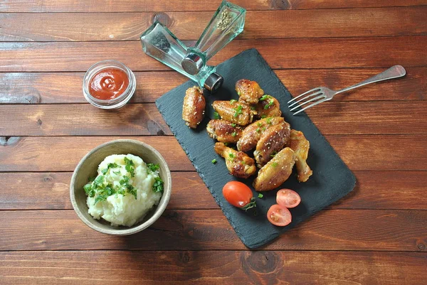 Izgara, Barbekü tavuk kanatları, akşam yemeği veya öğle yemeği için lezzetli yemekler. Susam ile kızarmış tavuk kanatları. Ahşap arka plan üzerinde fast food kavramı 