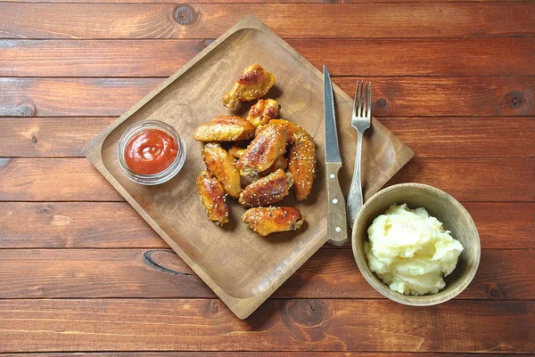 Izgara, Barbekü tavuk kanatları, akşam yemeği veya öğle yemeği için lezzetli yemekler. Susam ile kızarmış tavuk kanatları. Ahşap arka plan üzerinde fast food kavramı 