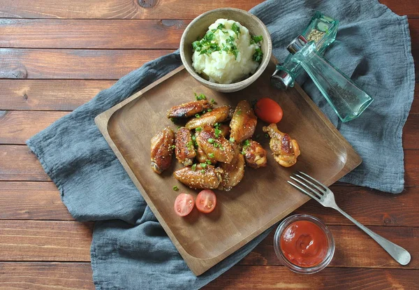 Izgara, Barbekü tavuk kanatları, akşam yemeği veya öğle yemeği için lezzetli yemekler. Susam ile kızarmış tavuk kanatları. Ahşap arka plan üzerinde fast food kavramı 