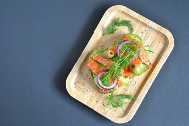 Avokado ile sağlıklı bütün tahıl crispbread yapıştırın, somon, zeytin, soğan, domates. Sağlıklı beslenme çanak