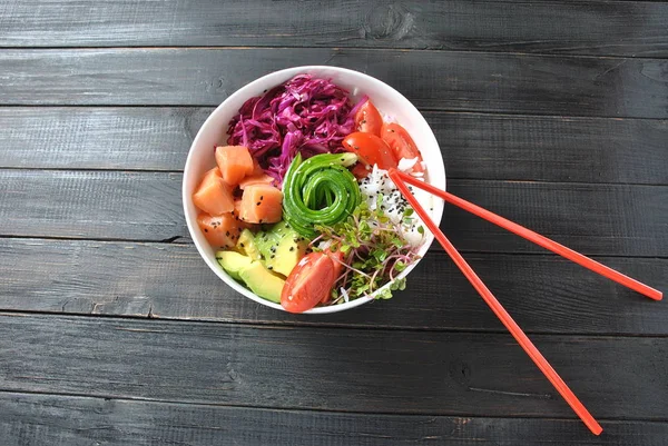 Organik gıda. Taze deniz ürünleri yemek tarifi. Taze somon poke kase pirinç, taze kırmızı lahana, avokado, kiraz domates, salatalık, turp lahanası ahşap arka plan üzerinde. Gıda kavramı poke kase 