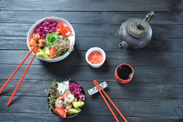 Organik gıda. Taze deniz ürünleri yemek tarifi. İki taze somon, karides, pirinç, kırmızı lahana, avokado, domates ile kase poke ve ahşap arka plan üzerinde turp lahanası. Gıda kavramı Poke kase 