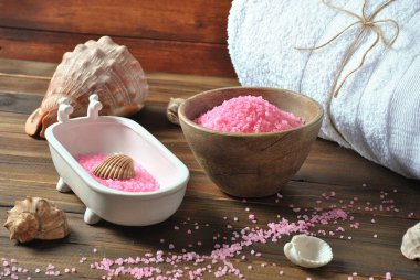 Spa ve vücut bakım ürünleri. Aromatik banyo Dead Sea Salt koyu ahşap arka plan üzerinde yükseldi. Ev yapımı Vücut tuz fırçalama için doğal maddeler. Dead Sea Kozmetik. Güzellik Cilt Bakımı. Kaplıca tedavisi. 