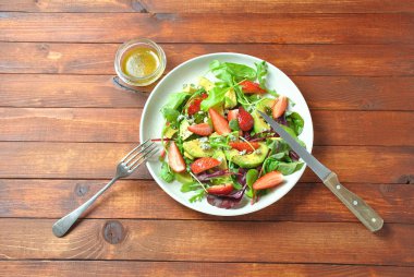 Avokado salatası çilek, mavi peynir, roka ve pancar ahşap arka plan üzerinde bırakır. Sağlıklı öğle yemeği kase Vegan sağlıklı gıda kavramı 