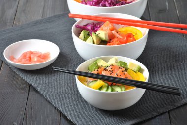 Kase taze somon, kristal erişte, turp, avokado, tatlı biber, salatalık, susam, kırmızı lahana ile poke. Organik gıda. Taze deniz ürünleri yemek tarifi. Gıda kavramı poke kase ahşap arka plan üzerinde 