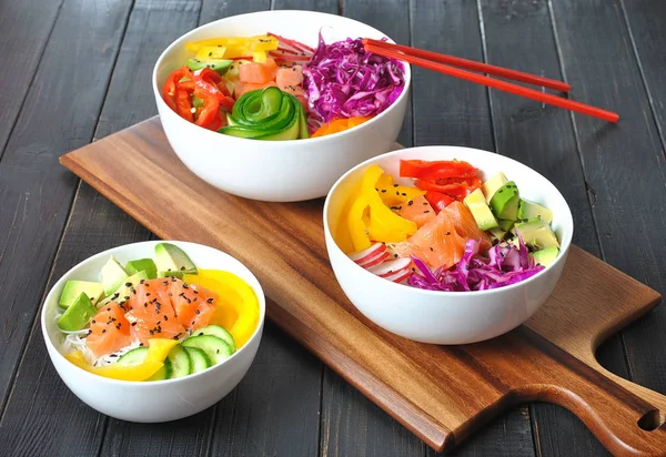 Kase taze somon, kristal erişte, turp, avokado, tatlı biber, salatalık, susam, kırmızı lahana ile poke. Organik gıda. Taze deniz ürünleri yemek tarifi. Gıda kavramı poke kase ahşap arka plan üzerinde 