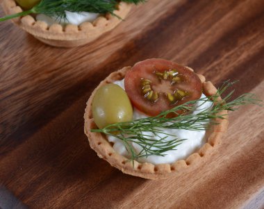 Tartlets taze somon, philadelphia krem peynir, zeytin ahşap arka plan üzerinde.
