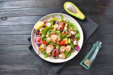 Avokado salata karides, cherry domates, roka pancar yaprakları, kırmızı soğan, sarı tatlı biber. Sağlıklı öğle yemeği tabak karides ve sebze ile 