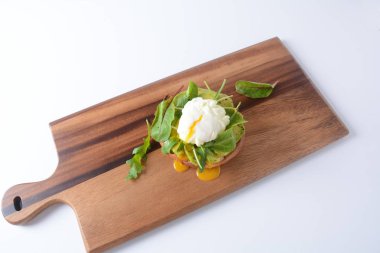 Pırasa ile haşlanmış yumurta. Ahşap plaka masanın üzerinde. Sandviç ekmeği, avokado ve roka pancar ile haşlanmış yumurta bırakır. Sağlıklı dengeli kahvaltı kavramı