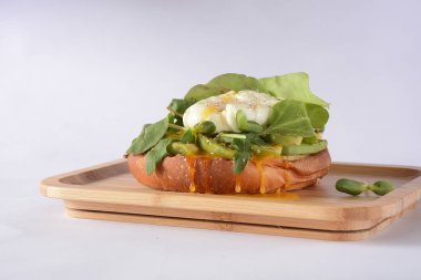 Pırasa ile haşlanmış yumurta. Ahşap plaka masanın üzerinde. Sandviç ekmeği, avokado ve roka pancar ile haşlanmış yumurta bırakır. Sağlıklı dengeli kahvaltı kavramı