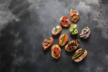 Brushetta veya geleneksel Ispanyol tapas. Italyan Antipasti aperatifler ile meze. Prosciutto ile küçük sandviç çeşitleri, kiraz domates, somon, krem peyniri, salatalık, turp, kuşkonmadan