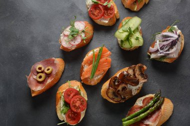 Brushetta veya geleneksel Ispanyol tapas. Italyan Antipasti aperatifler ile meze. Prosciutto ile küçük sandviç çeşitleri, kiraz domates, somon, krem peyniri, salatalık, turp, kuşkonmadan