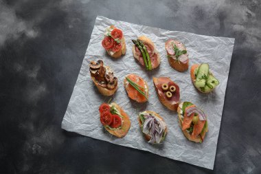Brushetta veya geleneksel Ispanyol tapas. Italyan Antipasti aperatifler ile meze. Prosciutto ile küçük sandviç çeşitleri, kiraz domates, somon, krem peyniri, salatalık, turp, kuşkonmadan