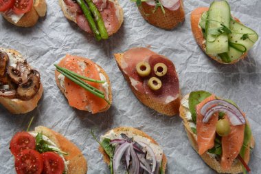Brushetta veya geleneksel Ispanyol tapas. Italyan Antipasti aperatifler ile meze. Prosciutto ile küçük sandviç çeşitleri, kiraz domates, somon, krem peyniri, salatalık, turp, kuşkonmadan