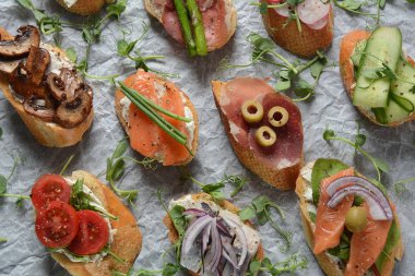 Brushetta veya geleneksel Ispanyol tapas. Italyan Antipasti aperatifler ile meze. Prosciutto ile küçük sandviç çeşitleri, kiraz domates, somon, krem peyniri, salatalık, turp, kuşkonmadan