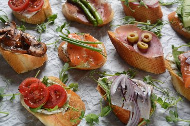 Brushetta veya geleneksel Ispanyol tapas. Italyan Antipasti aperatifler ile meze. Prosciutto ile küçük sandviç çeşitleri, kiraz domates, somon, krem peyniri, salatalık, turp, kuşkonmadan
